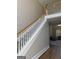 Classic staircase with white spindles, wood banister, and views to the living room at 135 Danube Trl, Stockbridge, GA 30281