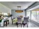 Bright dining area featuring a stylish light fixture, dining table, and large window with natural light at 2582 Rosecommons Dr, Hampton, GA 30228