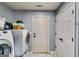 Well-lit laundry room with white washer and dryer, grey walls, and white marble-look floor at 2582 Rosecommons Dr, Hampton, GA 30228