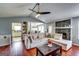 Open-concept living area with hardwood floors, stone fireplace, comfortable seating, and kitchen access at 2582 Rosecommons Dr, Hampton, GA 30228