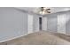 Spacious bedroom with neutral carpet, ceiling fan, and three closet doors for storage at 2998 Kenville Ln, Decatur, GA 30034