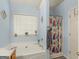 A bathroom featuring a large soaking tub and a shower with a colorful curtain at 2040 Elm Grove Ln, Hampton, GA 30228