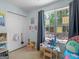 A bedroom featuring a large window, bright blue walls and lots of closet space at 2040 Elm Grove Ln, Hampton, GA 30228