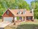 Well-manicured lawn and landscaping complements this single Gathering home with a 2-car garage at 2040 Elm Grove Ln, Hampton, GA 30228