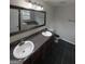 Bathroom features a dual sink vanity, framed mirror, and dark tile floors at 1232 Memorial Se Dr, Atlanta, GA 30316