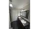 Bathroom featuring dual sink vanity, framed mirror, dark tile floors, and white doors at 1232 Memorial Se Dr, Atlanta, GA 30316