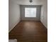 Empty bedroom with hardwood floors, a ceiling light, and a large window at 1232 Memorial Se Dr, Atlanta, GA 30316