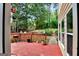 Spacious red back deck with a grill and lawn decor overlooking the trees in the backyard at 4335 Burgomeister Pl, Snellville, GA 30039