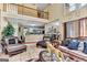 Open-concept living room with a two-story ceiling, kitchen view, and cozy seating at 4335 Burgomeister Pl, Snellville, GA 30039