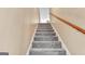 Carpeted staircase with wooden handrail leads to the upper level of this beautifully designed home at 4335 Burgomeister Pl, Snellville, GA 30039