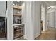 Bar area with beverage cooler, shelving, and tiled backsplash perfect for entertaining guests and mixing drinks at 175 Central Ave, Fayetteville, GA 30214