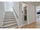 Hallway with stairs, access to the laundry room, and wood flooring, providing a welcoming entrance at 175 Central Ave, Fayetteville, GA 30214