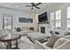 Bright living room with white walls, modern ceiling fan, fireplace, large tv, and comfortable neutral-toned furniture at 175 Central Ave, Fayetteville, GA 30214