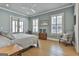 Serene main bedroom featuring a sitting area, ample natural light, hardwood floors, and neutral color palette at 175 Central Ave, Fayetteville, GA 30214