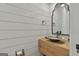 Stylish powder room with wood-look plank wall, modern vanity, vessel sink, and a sleek mirror at 175 Central Ave, Fayetteville, GA 30214
