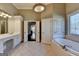 Bathroom with double sink vanity, tiled floors, and soaking tub at 10125 Brixton Pl, Suwanee, GA 30024