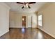 Spacious bedroom with hardwood floors, a ceiling fan, and an ensuite bathroom entrance at 10125 Brixton Pl, Suwanee, GA 30024
