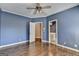 Bright bedroom with blue walls, modern ceiling fan, and an ensuite bathroom entrance at 10125 Brixton Pl, Suwanee, GA 30024