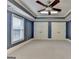 Bedroom features blue walls, carpet floors, and ceiling fan with lighting at 10125 Brixton Pl, Suwanee, GA 30024