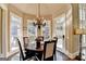 Sunlit dining room with hardwood floors, chandelier, and multiple windows at 10125 Brixton Pl, Suwanee, GA 30024