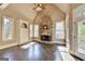 Cozy living room featuring a stone fireplace, hardwood flooring, natural light and a ceiling fan at 10125 Brixton Pl, Suwanee, GA 30024