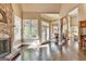 Living room features a stone fireplace, hardwood flooring, natural light and entryway to dining area at 10125 Brixton Pl, Suwanee, GA 30024