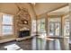 Living Room with stone fireplace, hardwood flooring, natural light and entry to the outside patio at 10125 Brixton Pl, Suwanee, GA 30024