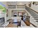 Bright living room with fireplace, hardwood floors, and staircase with iron railings at 10125 Brixton Pl, Suwanee, GA 30024