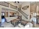Bright living room with fireplace, hardwood floors, and staircase with iron railings at 10125 Brixton Pl, Suwanee, GA 30024