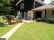 Spacious backyard patio area with outdoor seating, a grill, and beautifully landscaped garden beds at 4213 Janice Drive, Atlanta, GA 30337