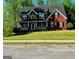 Charming two-story red brick home with a welcoming front porch and manicured lawn in a serene, wooded setting at 419 Tea Rose N Ln, Stockbridge, GA 30281