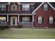 Traditional two story brick home with a cozy front porch and well manicured lawn at 419 Tea Rose N Ln, Stockbridge, GA 30281