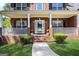 Charming red brick home featuring a welcoming front porch with white columns and manicured landscaping at 419 Tea Rose N Ln, Stockbridge, GA 30281