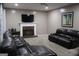 Comfortable living room with a brick fireplace, TV, plush leather seating, and neutral carpet at 419 Tea Rose N Ln, Stockbridge, GA 30281