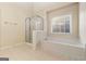 Bathroom featuring a soaking tub, a glass enclosed shower and a window allowing for plenty of natural light at 6281 Vinings Vintage Dr, Mableton, GA 30126