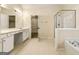 Bright bathroom featuring a dual sink vanity, glass enclosed shower and a walk-in closet with shelving at 6281 Vinings Vintage Dr, Mableton, GA 30126