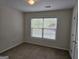 Bedroom with neutral walls, standard lighting, and a view of the yard through the window at 6281 Vinings Vintage Dr, Mableton, GA 30126