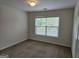 Neutral bedroom with standard lighting and a window view of the backyard at 6281 Vinings Vintage Dr, Mableton, GA 30126