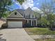 Charming two-story home with a brick and siding exterior, attached garage, and well-maintained lawn at 6281 Vinings Vintage Dr, Mableton, GA 30126