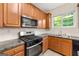 A well-lit kitchen features wood cabinets, black appliances, and a tile backsplash at 6281 Vinings Vintage Dr, Mableton, GA 30126