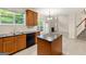 A well-lit kitchen features wood cabinets, black appliances, and an island adjacent to the living room at 6281 Vinings Vintage Dr, Mableton, GA 30126