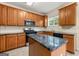 A well-lit kitchen features wood cabinets, black appliances, a tile backsplash, and an island at 6281 Vinings Vintage Dr, Mableton, GA 30126
