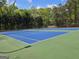 Outdoor tennis court with well-maintained blue and green surface, surrounded by greenery at 6281 Vinings Vintage Dr, Mableton, GA 30126