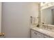 Neutral half bath with a white vanity, speckled granite countertop, and a framed mirror at 310 Hamdon Kells, Peachtree City, GA 30269
