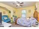 Yellow bedroom with natural light features a cozy bed, comfortable chair, and decorative accents at 310 Hamdon Kells, Peachtree City, GA 30269