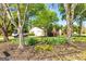 Landscaped front yard with mature trees framing the house and driveway, providing a serene setting at 310 Hamdon Kells, Peachtree City, GA 30269