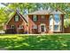 Charming brick home with lush green lawn and mature landscaping, offering great curb appeal at 310 Hamdon Kells, Peachtree City, GA 30269