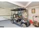 Spacious garage with a golf cart parked inside and shelves for storage, along with a lawnmower at 310 Hamdon Kells, Peachtree City, GA 30269