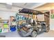 Bright garage contains golf cart, shelves, and ample storage to keep the space organized and clean at 310 Hamdon Kells, Peachtree City, GA 30269