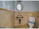 Small, unfinished bathroom featuring toilet and sink with tile walls at 345 Phillips Dr, Fayetteville, GA 30214